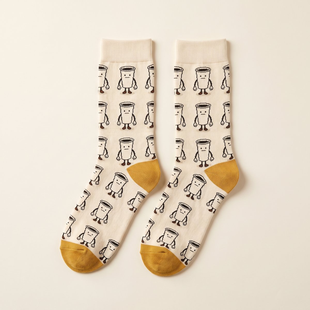 Cream crew socks with mustard toes, knitted with a repeating pattern of Drip.